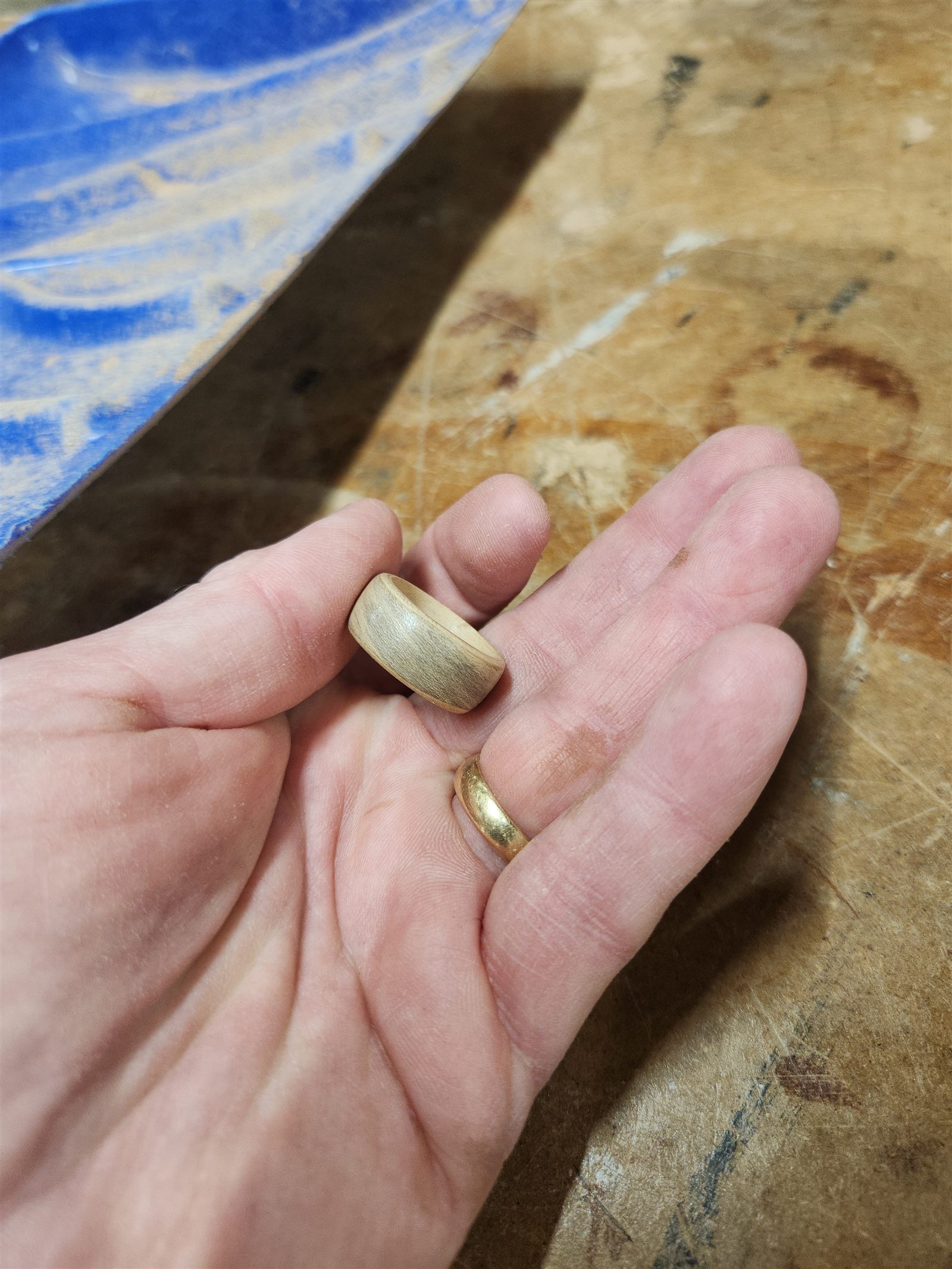 Dermot's hand holding a small turned wooden ring